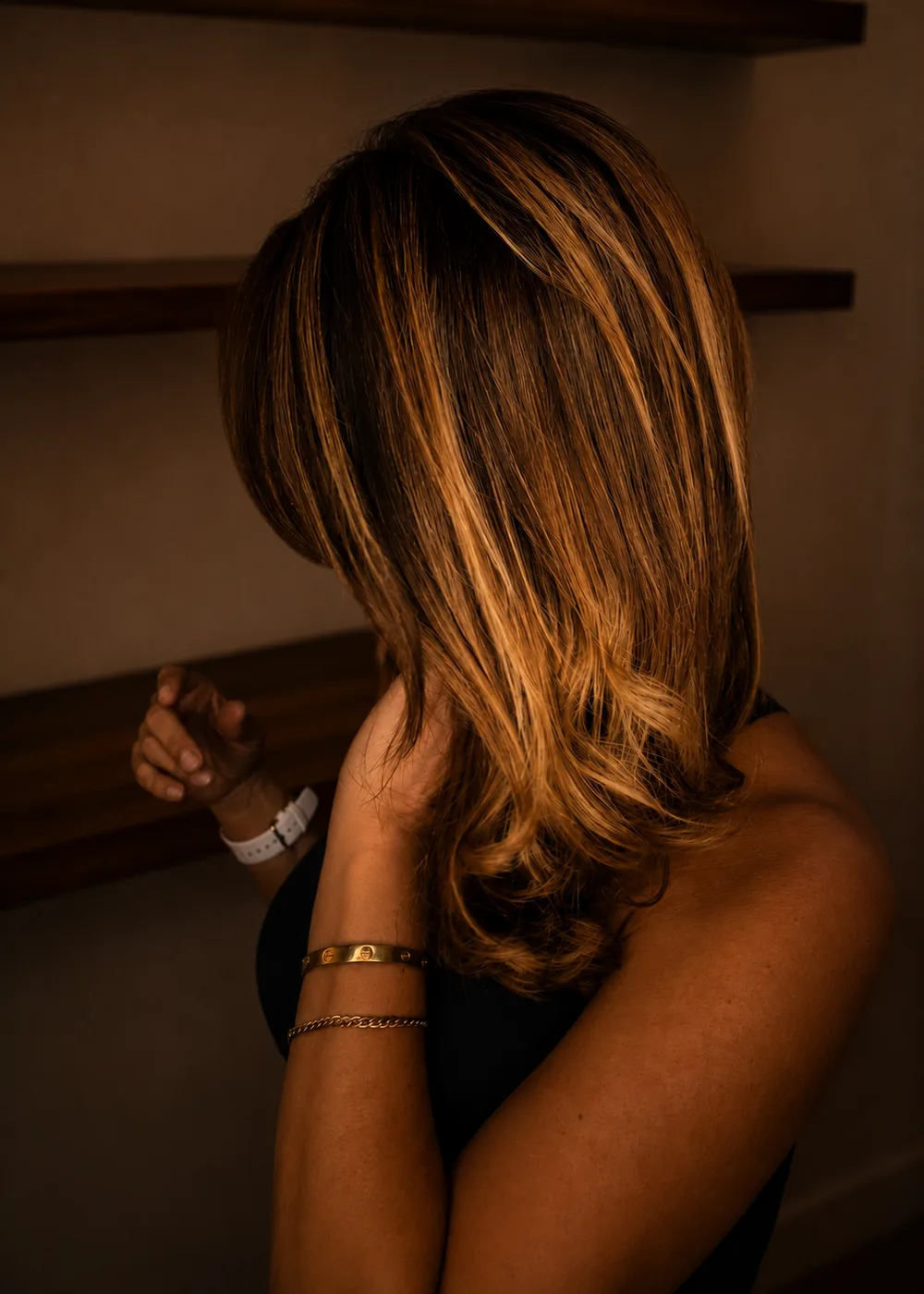 Mid-length wavy brunette hair with golden caramel balayage at Glow Hair Studio